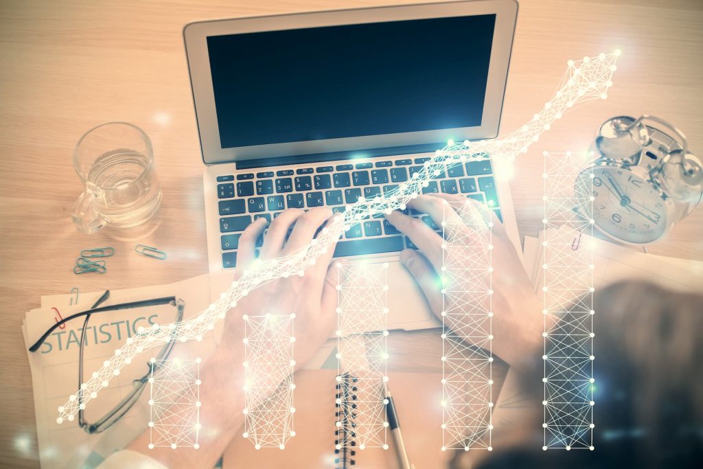 doble-exposicion-de-las-manos-del-hombre-escribiendo-en-el-teclado-de-la-computadora-portatil-y-dibujo-de-hologramas-de-graficos-de-divisas-vista-superior-concepto-de-mercados-financieros